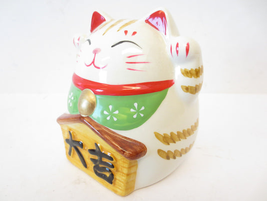 Glckskatze auf rotem Kissen